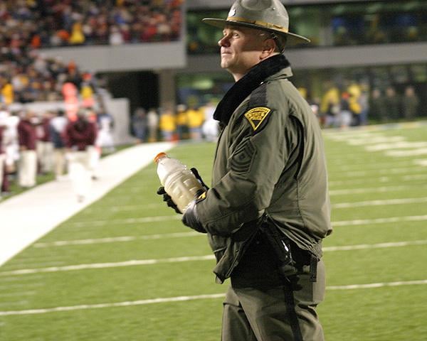 Lethal weapon: a police officer, holding a Gatorade bottle of sand thrown out of the stands during the 2003 VT-WVU game