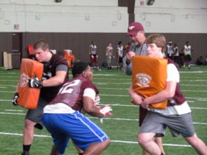 Minor, in the maroon jersey, performs a drill in front of Coach Searels.